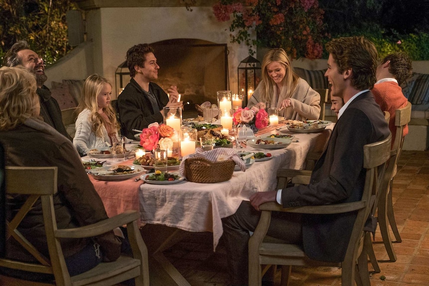 Colour still image from 2017 film Home Again featuring the main cast in a dinner table scene.