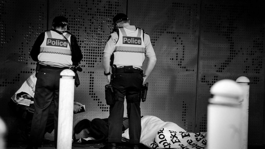 Police move along a homeless person in Melbourne.