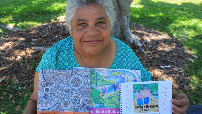 Indigenous Elder Nicky Hatfield with the three books she's written in Darumbal language