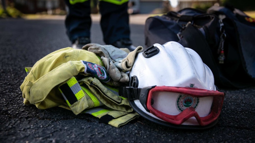 A small pile of protective clothing, including a helmet, on the side of a road