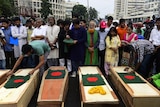 Bangladeshi activists place national flags on mock coffins, that symbolise the deaths of secular publishers and bloggers.