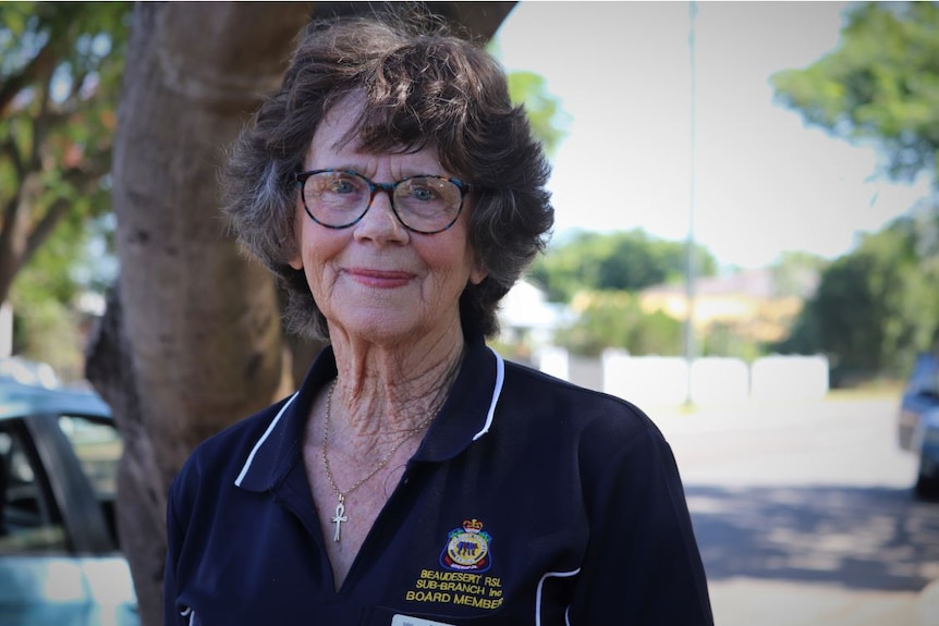 A woman wearing a beaudesert rsl sub branch polo shirt smiles at the camera