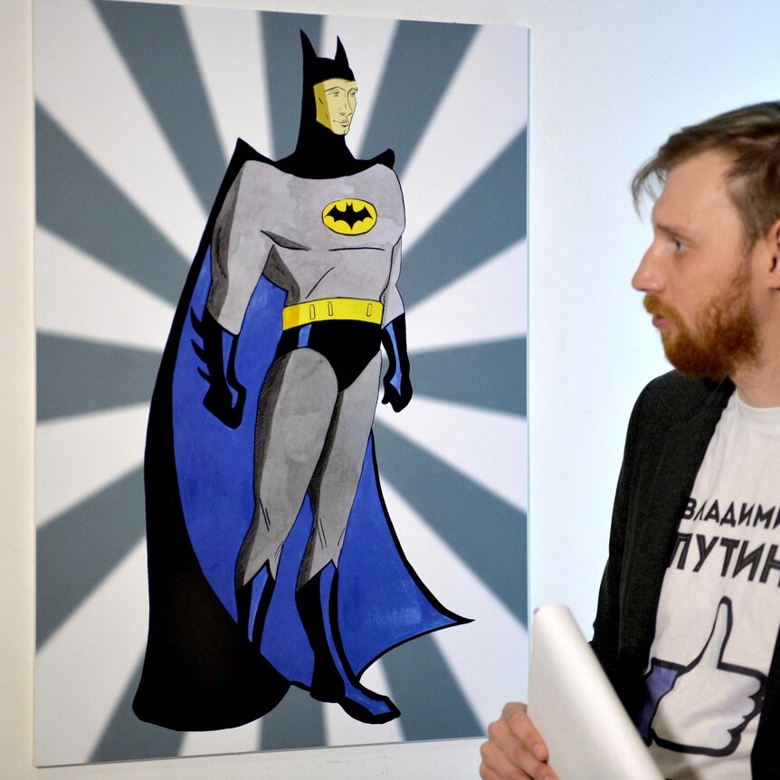 A visitor looks at an artwork depicting Russian President Vladimir Putin as Batman.