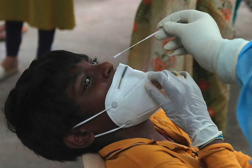 A boy gets a nasal swab sample taken in Hyderabad, India.