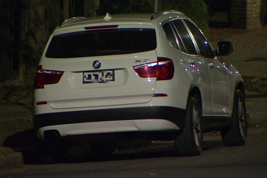 Un SUV BMW blanco estacionado en la calle por la noche