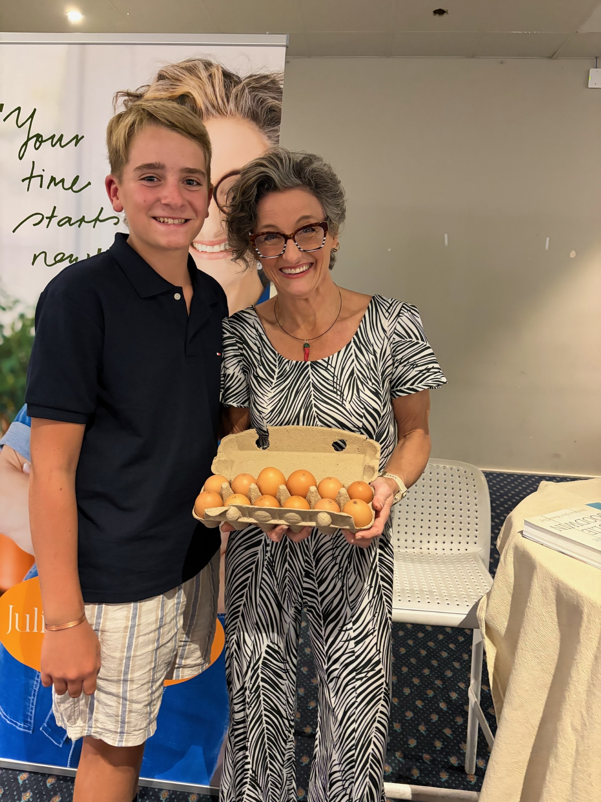 Un adolescente y una mujer sostienen un cartón de huevos.