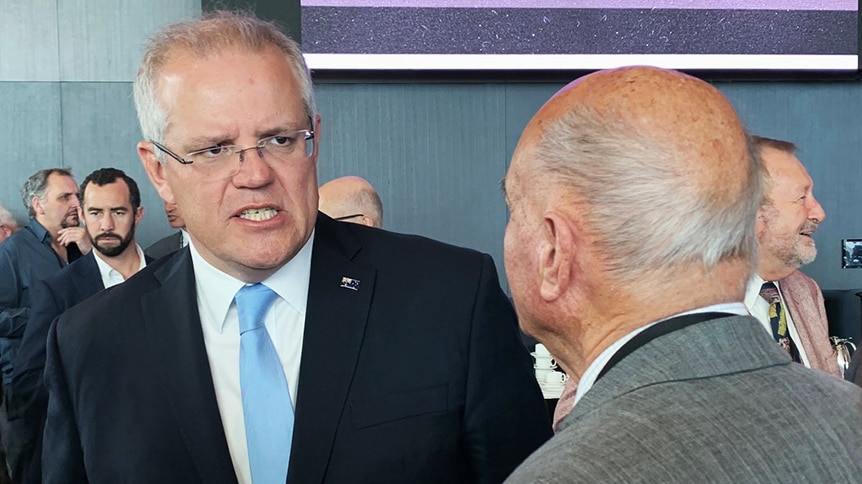 Prime Minister Scott Morrison speaks to an unidentified man.