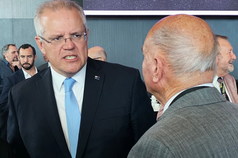 Prime Minister Scott Morrison speaks to an unidentified man.