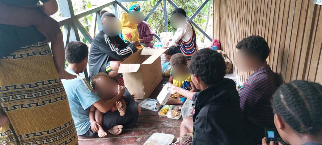 A group of PNG women and babies sitting on a verandah 