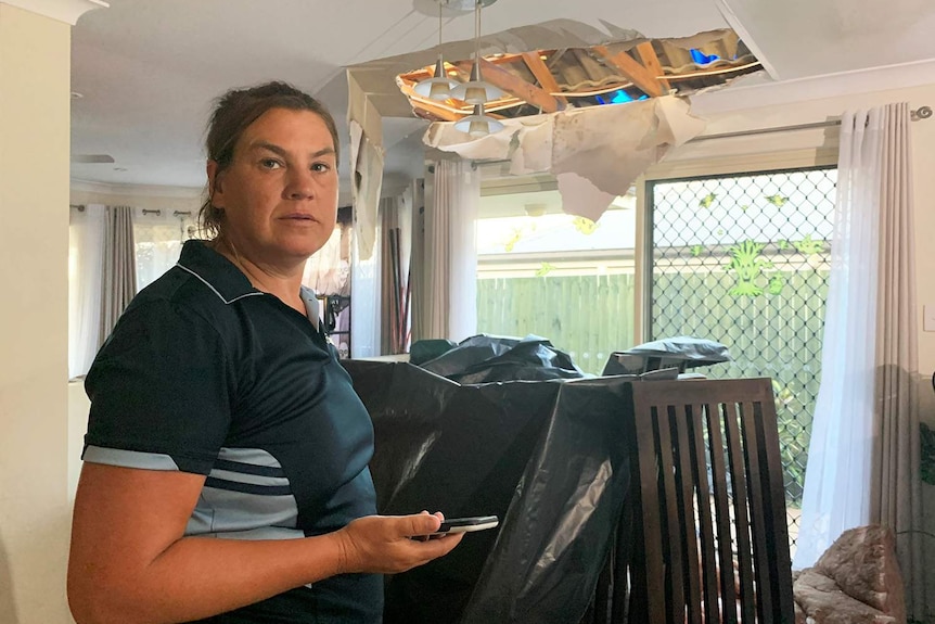 Beverly Mills in her storm-damaged house with the ceiling caved in.