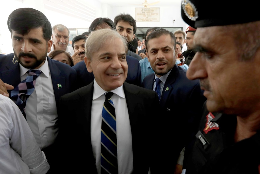Pakistan opposition leader Shehbaz Sharif surrounded by a crowd of men.