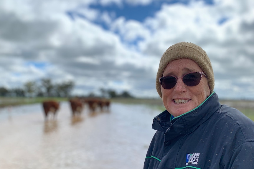 anne earney with floodwater behind on property