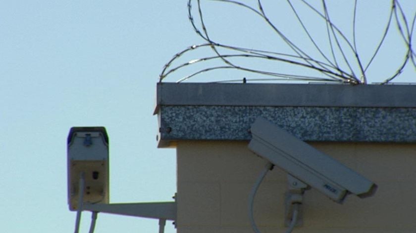 Security cameras and razor wire at a jail.