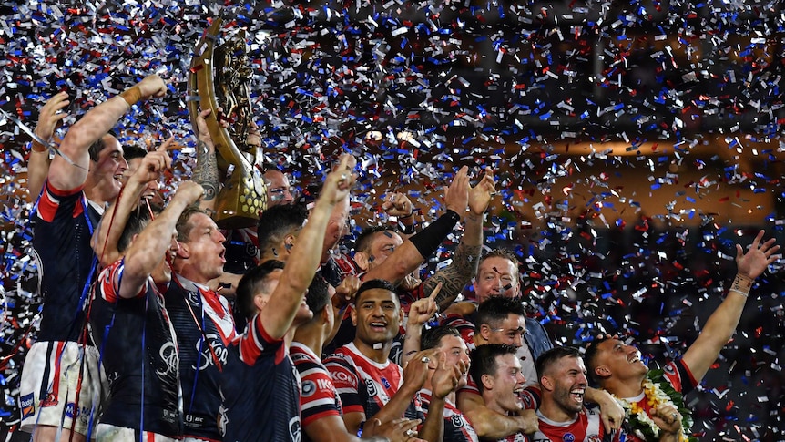 The Sydney Roosters lift the NRL trophy as glitter rains down.