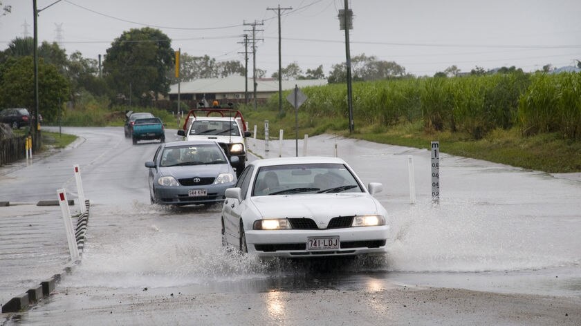 No damage yet...Mackay residents make their way through the floodwaters.