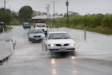 No damage yet...Mackay residents make their way through the floodwaters.