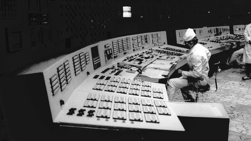 A technician monitors computers and a control board