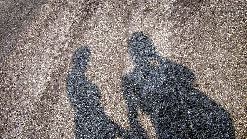 The shadow of two teenagers holding hands