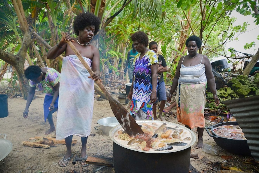 A woman stirs a pot of sea cucumbers