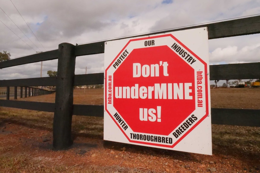 A sign on a gate reads 'Don't undermine us'.