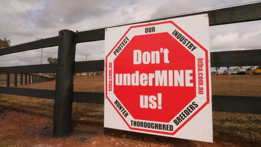 A sign on a gate reads 'Don't undermine us'.