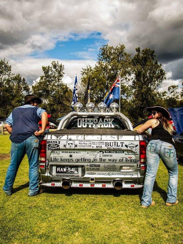 Man and woman stand with a ute.