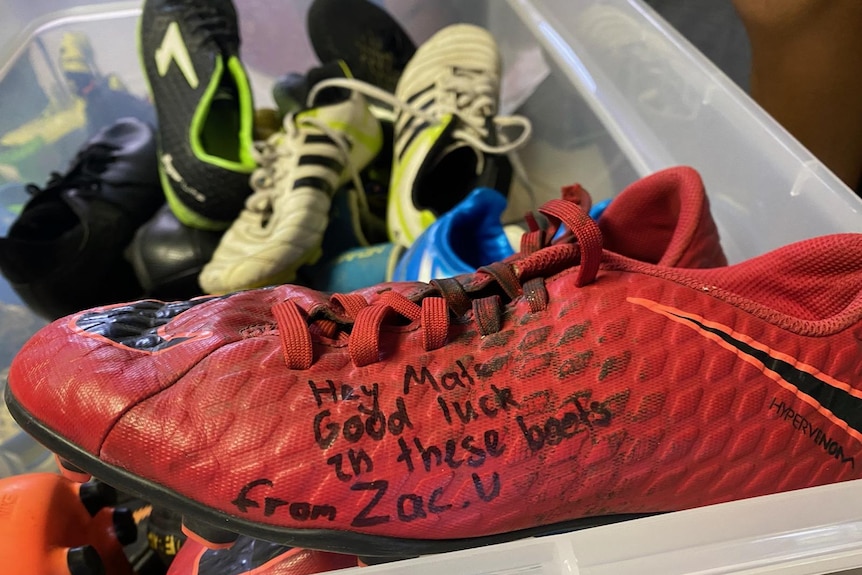 A red football boot with the message, Hey Mate, good luck in these boots from Zac.