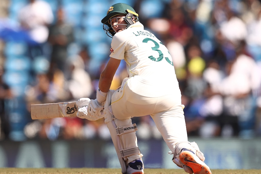 An Australian male batter sweeps against India during a test in Nagpur.