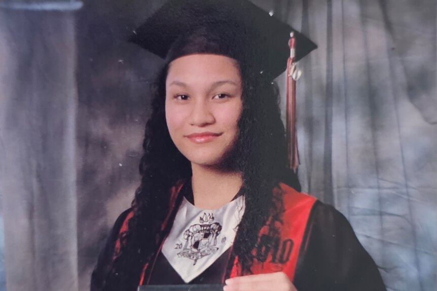 Teenager in graduating gown at high school graduation in Guam
