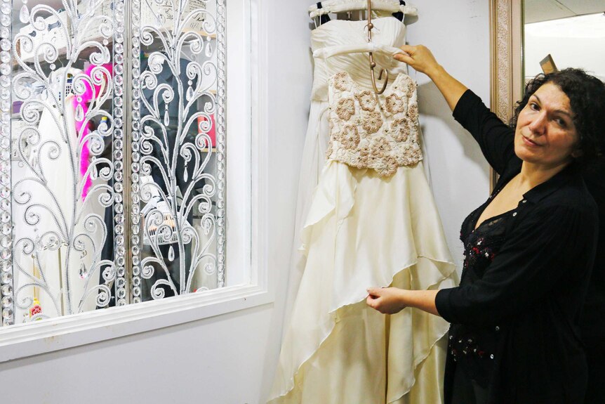 Hajar Gala holding dress in studio by window