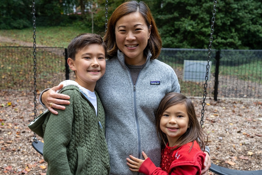 Sandy stands between her two children. 