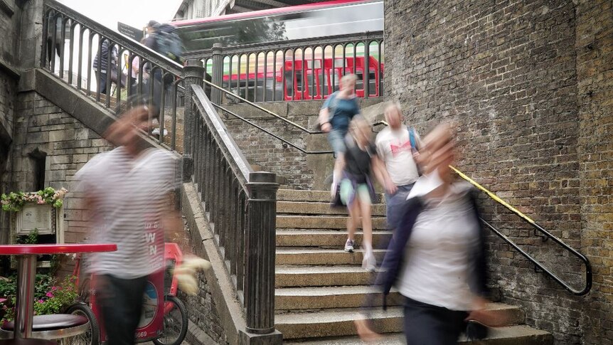 People walking on stairs which lead onto London Bridge.