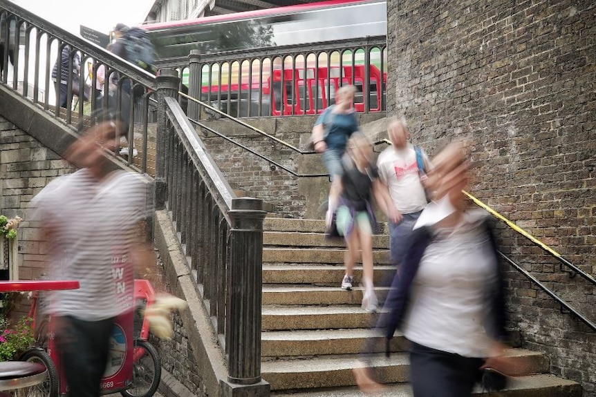 People walking on stairs which lead onto London Bridge.