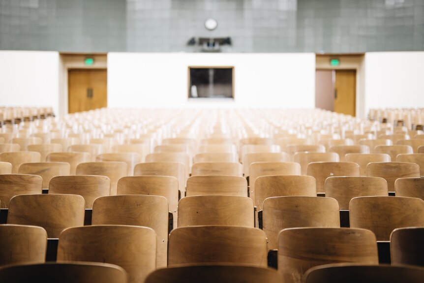 Empty chairs in an empty school auditorium. 