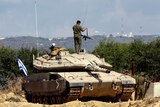  An Israeli soldier adjusts his rifle as he stands on a tank near Israel's border with Lebanon.