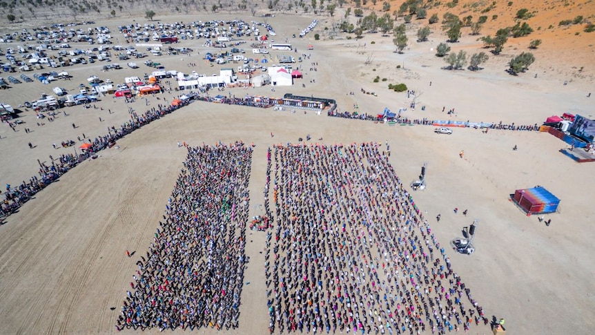 An aerial photo of the event with many people in a square formation.