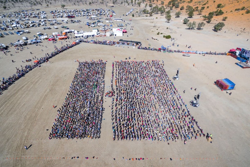 An aerial photo of the event with many people in a square formation.