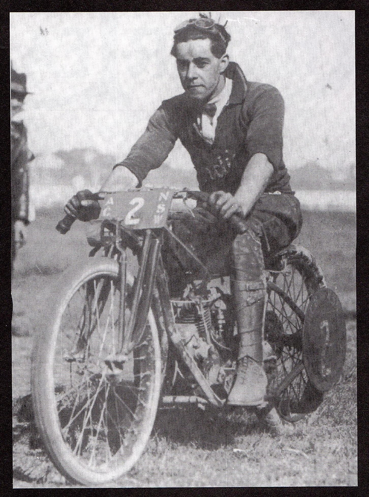 Dave Brewster sits on a motorcycle, wearing a three quarter length shirt.