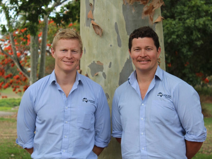 Casey and Luke Brown stand next to each other, gumtree in background