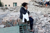 A woman among rubble following a quake in Amatrice, central Italy, on August 24, 2016.