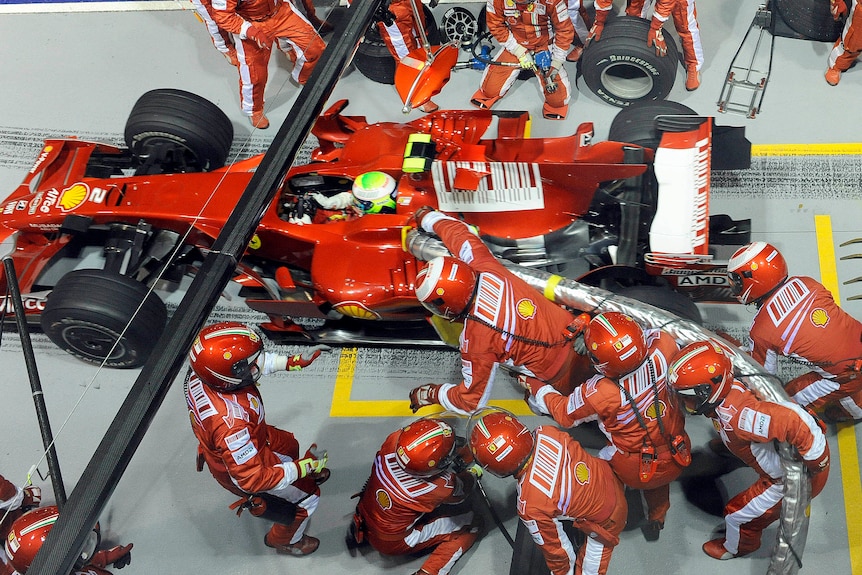 Multiple pit crew members for Ferrari fail to remove a fuel hose which is attatched to a car leaving the pit lane