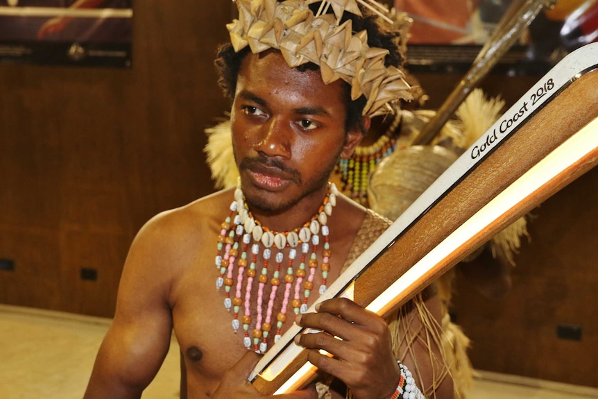 A young Ni-Vanuatu man in traditional dress holds the Queen’s Baton.