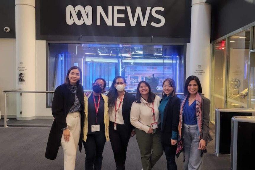 Six women stand for a group shot in front of ABC News studio public viewing window.
