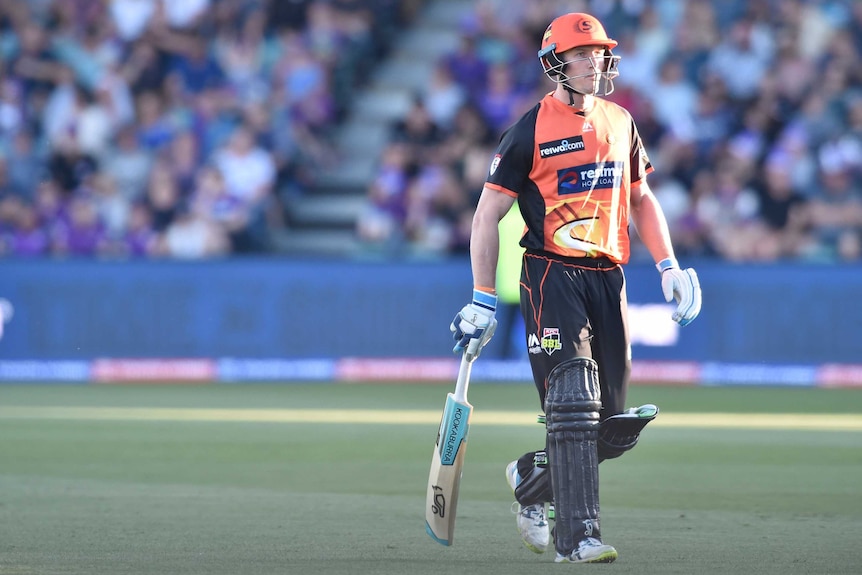 Cameron Bancroft walks off the field, a cricket bat in his hand.