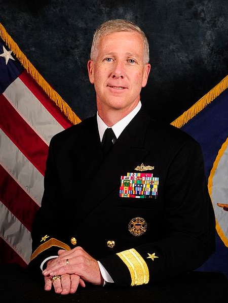 A man with pale grey hair wearing a former naval uniform.