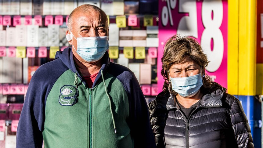 Two people wearing masks on the street