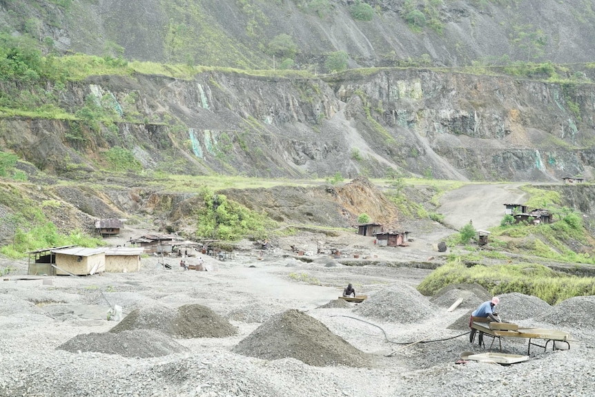 Men can be seen panning for gold at the bottom of the mine.