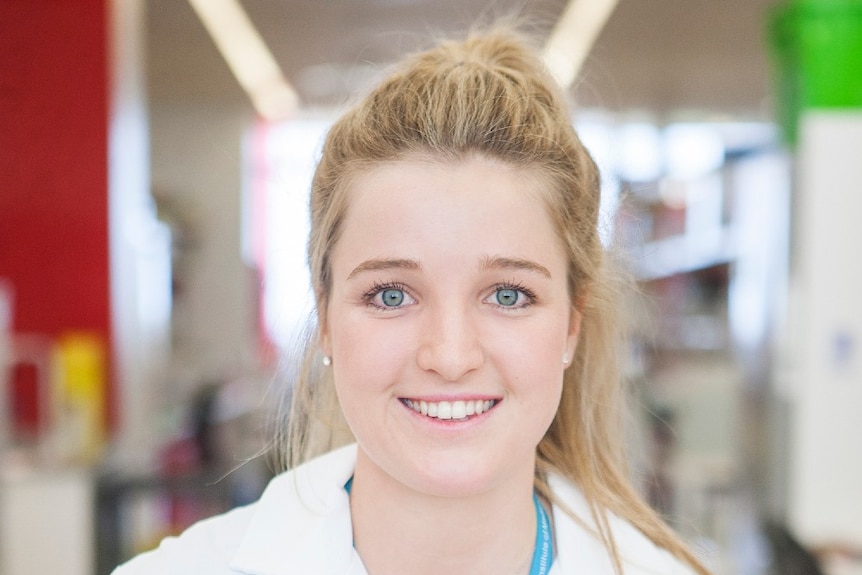 A portrait shot of Ciara Duffy in a lab wearing a white lab coat and smiling at the camera.