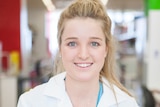 A portrait shot of Ciara Duffy in a lab wearing a white lab coat and smiling at the camera.