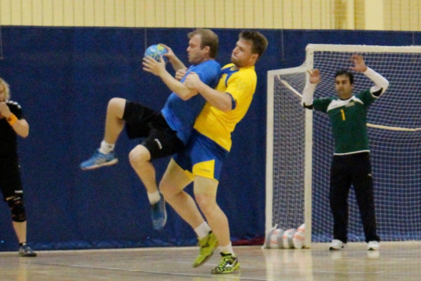Two men play handball.
